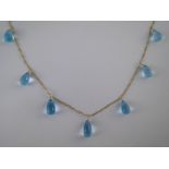 A yellow metal  (tests 18 carat gold) blue topaz necklace, each topaz approx 15 x 8mm,
