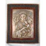 A large white metal Orthodox icon of  Virgin and Child in moulded faux tortoiseshell frame 45x36cm.