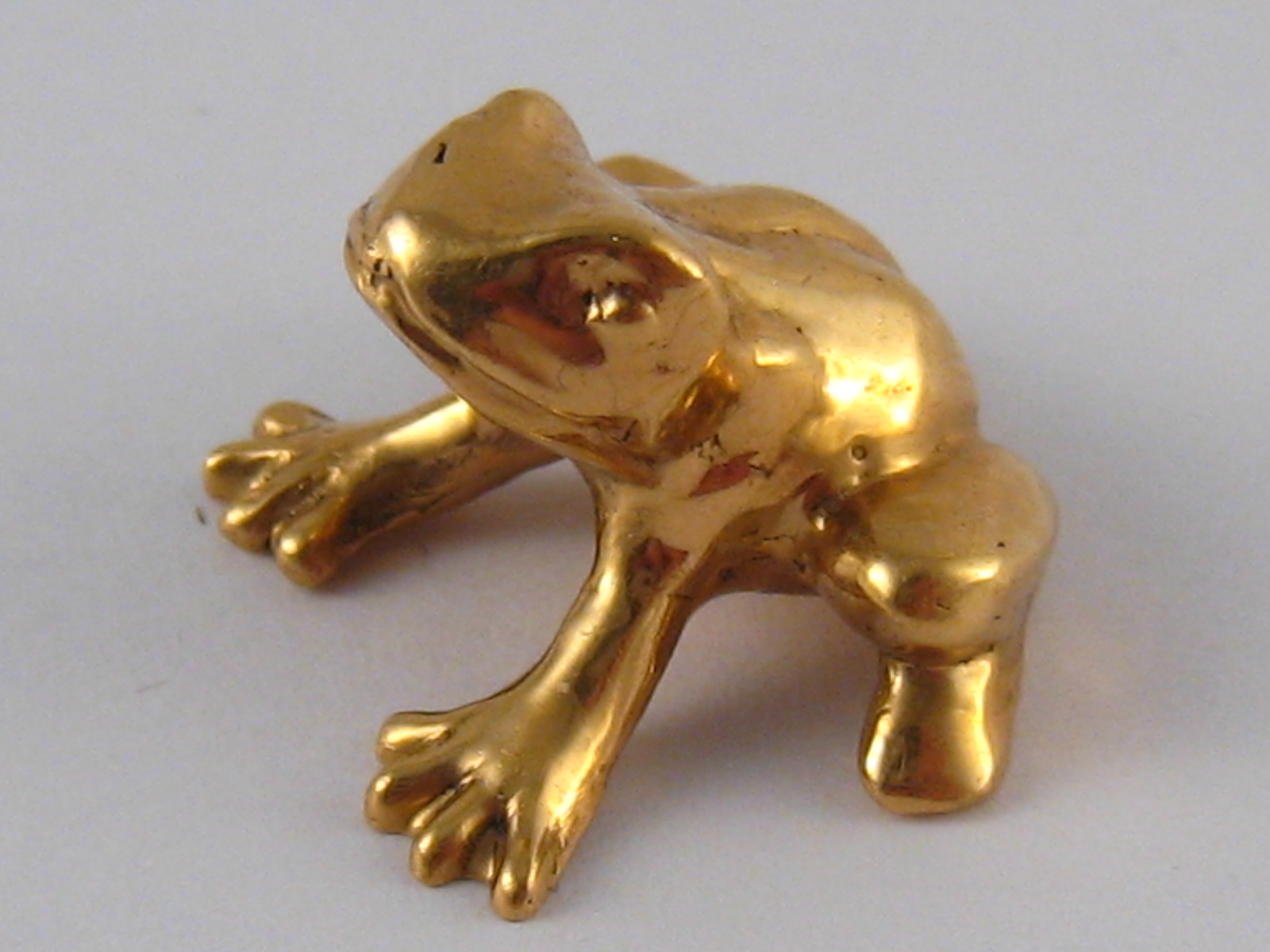 A yellow metal (tests 18 carat gold) model of a frog, approx 2cm wide, 16.5 gms.