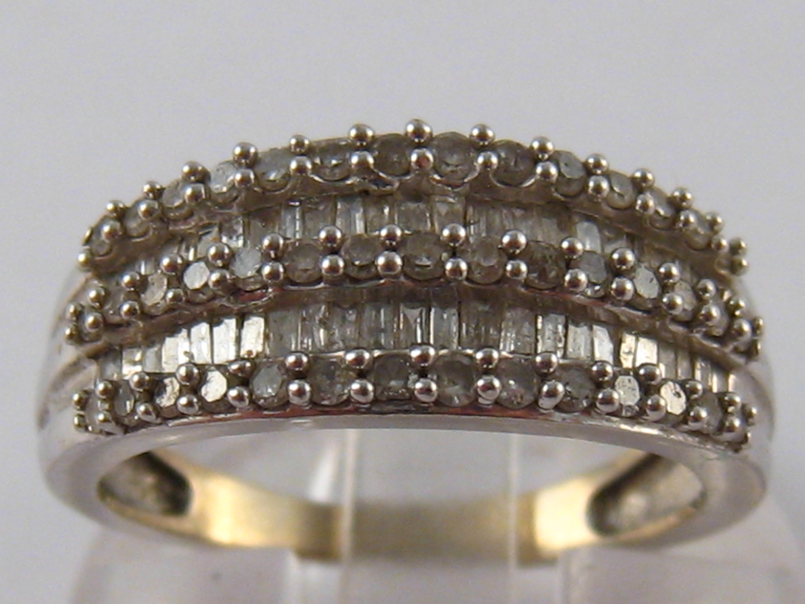 A white metal (tests 9 carat gold) diamond ring, size N, 3.6 gms.