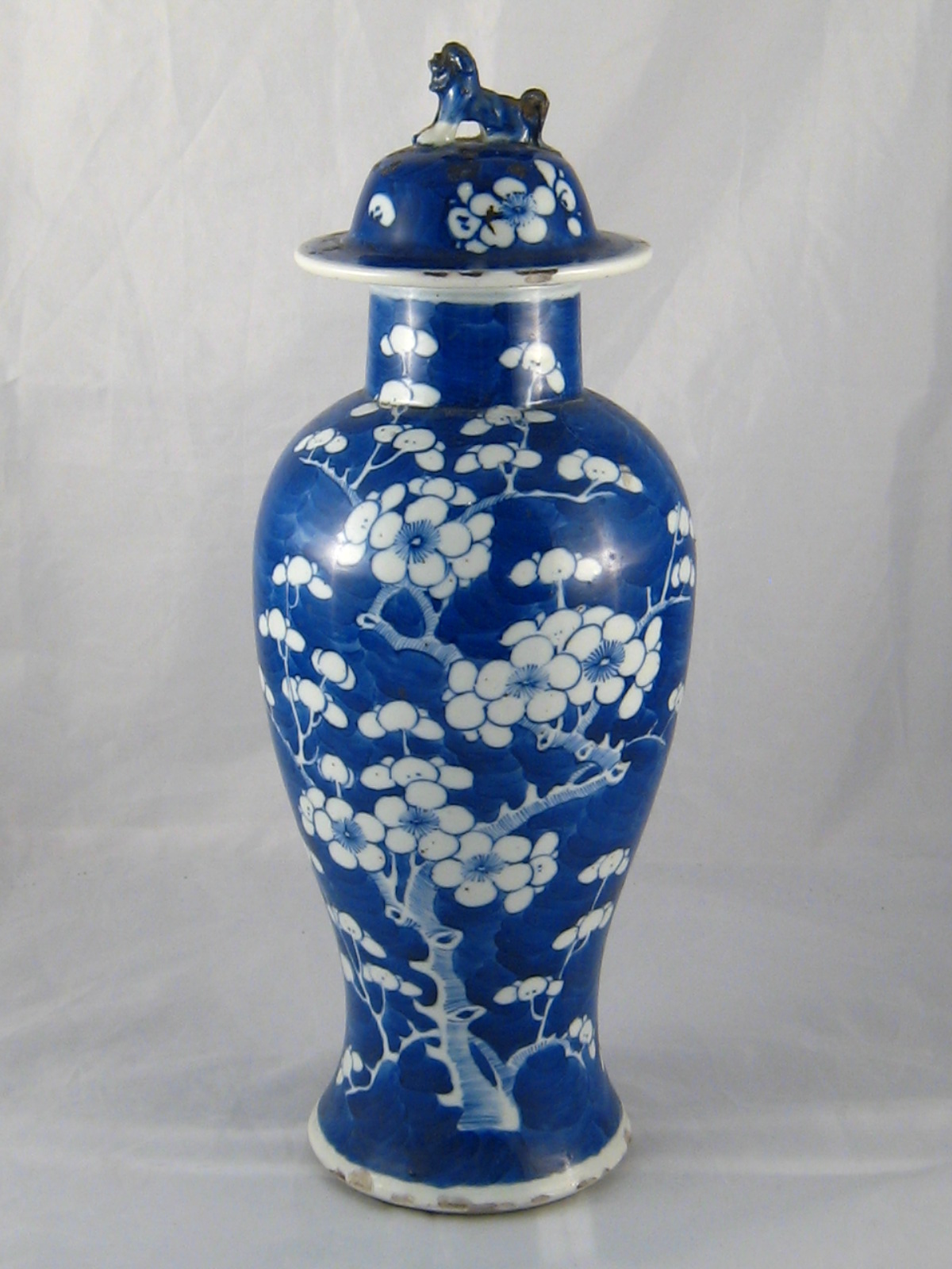 A Chinese ceramic baluster vase with white prunus on a blue ground,