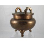 A Chinese bronze censer on three stub legs with engraved decoration ,