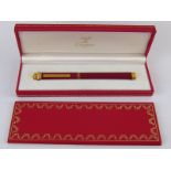 A boxed Must de Cartier ball point pen.