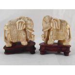 A pair of carved ivory caparisoned elephants, circa 1920, ht. 7cm. with later stands.
