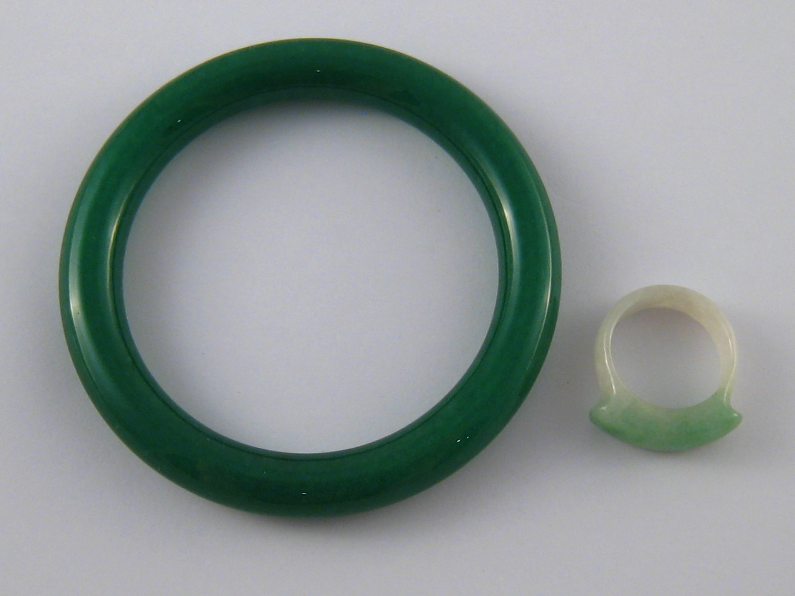 A mixed lot comprising a carved jade ring (size R) and a green hardstone bangle.