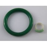 A mixed lot comprising a carved jade ring (size R) and a green hardstone bangle.