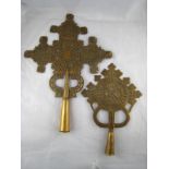 Two Ethiopian brass processional cross finials, one particularly intricately worked. 38x52cm.