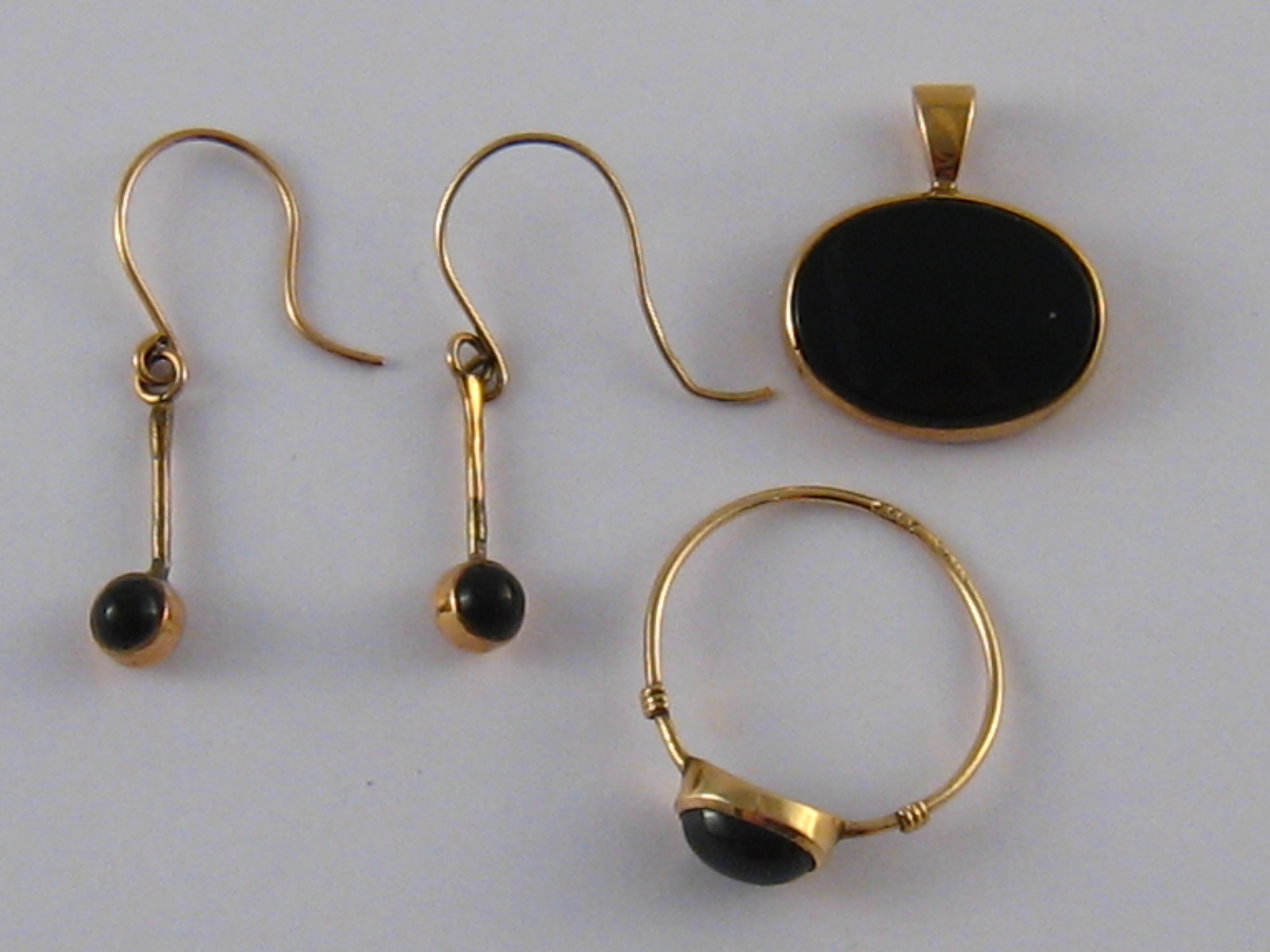 A suite of 9 carat gold onyx jewellery comprising ring, earrings and pendant, gross weight 3.