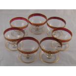 Seven grapefruit glasses with gilt ruby rims.