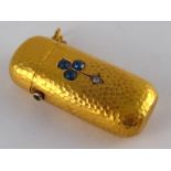 An antique 18 carat gold sapphire and diamond hammered effect vesta case, sapphire set button,