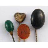 A mixed lot comprising three stick pins (two antique) and a hat pin.