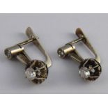 A pair of white metal (tests 18 carat gold) diamond earrings, unascribed marks,