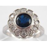 A white metal (tests 18 carat gold) sapphire and diamond ring,