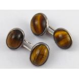A pair of white metal (tests silver) tiger's eye cufflinks, marked 830, stones approx 12 x 9mm, 7.