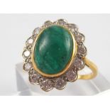 An 18 carat gold cabochon emerald and diamond ring, marked MM, emerald approx 13 x 10mm,