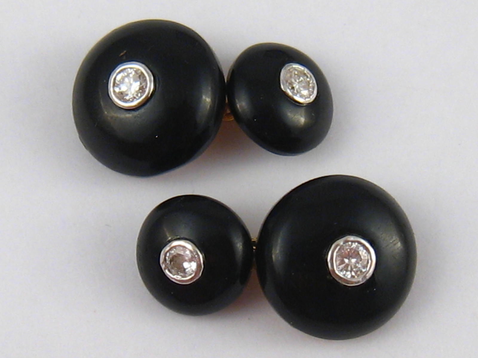 A fine pair of yellow metal (tests 18 carat gold) diamond and onyx cufflinks,