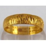 A 22 carat gold “bark” effect band ring, size N, 3 gms.