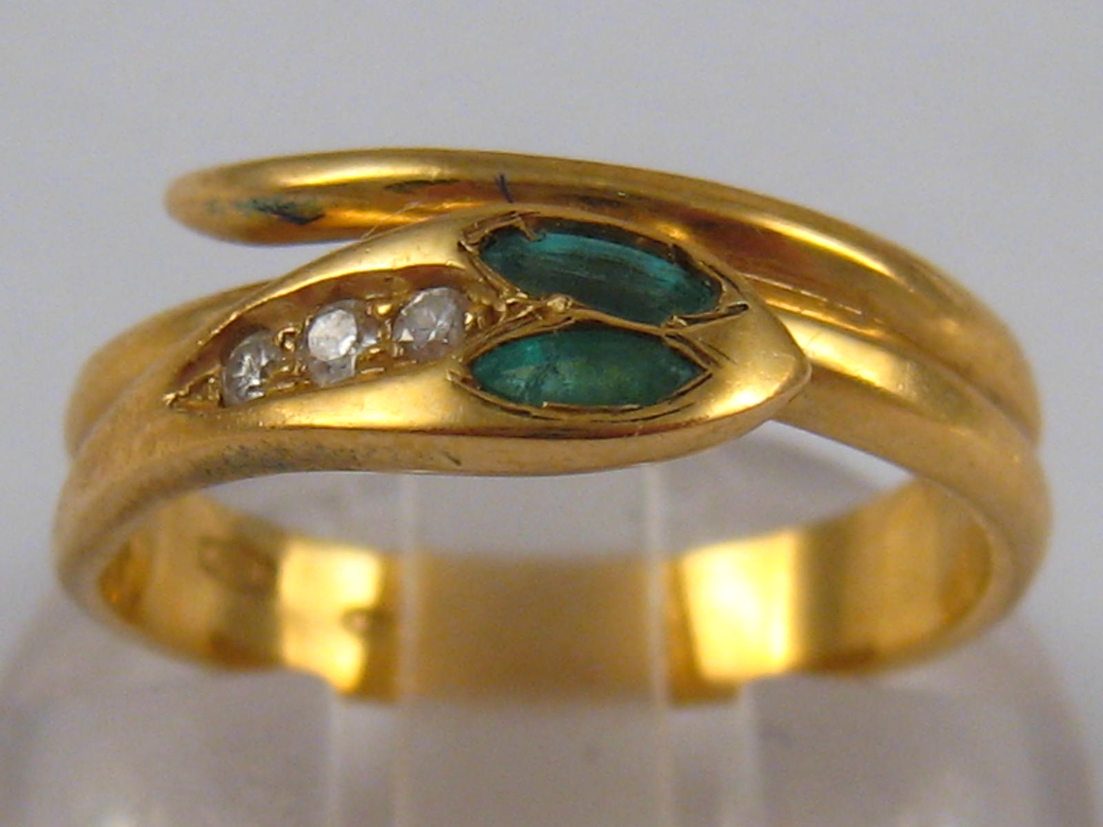 An 18 carat gold emerald and diamond snake ring, size L, 3.5 gms.