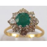 An 18 carat gold emerald and diamond cluster ring, the emerald measuring approx. 5.