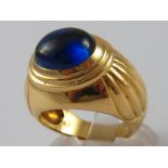 A yellow metal (tests 18 carat gold) cabochon synthetic sapphire ring, size L, 14.3 gms.