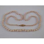 A graduated cultured pearl necklace with a yellow metal (tests 14 carat gold) clasp,