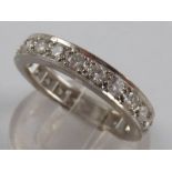 A fine white metal (tests 18 carat gold) diamond eternity ring,