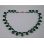 A yellow metal (tests 18 carat gold) emerald bead necklace,