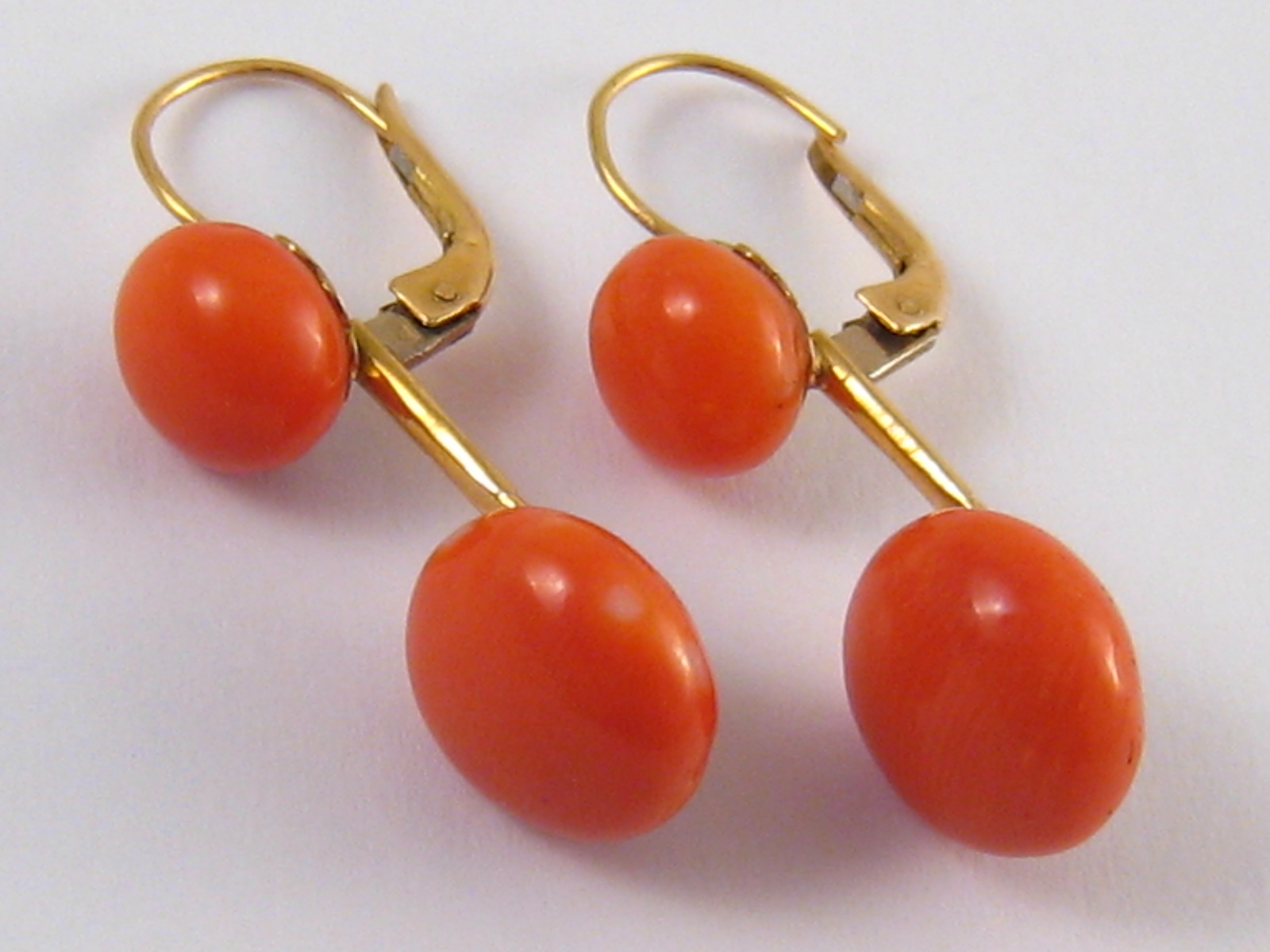 A pair of yellow metal (tests 18 carat gold) coral drop earrings, larger corals approx 12 - 12.