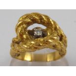 A yellow metal (tests 18 carat gold) “rope” ring, set with a solitaire round brilliant cut diamond,