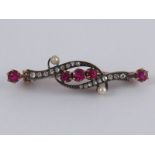 A boxed antique ruby, diamond and seed pearl brooch, approx 4.5cm long, 4.8 gms.