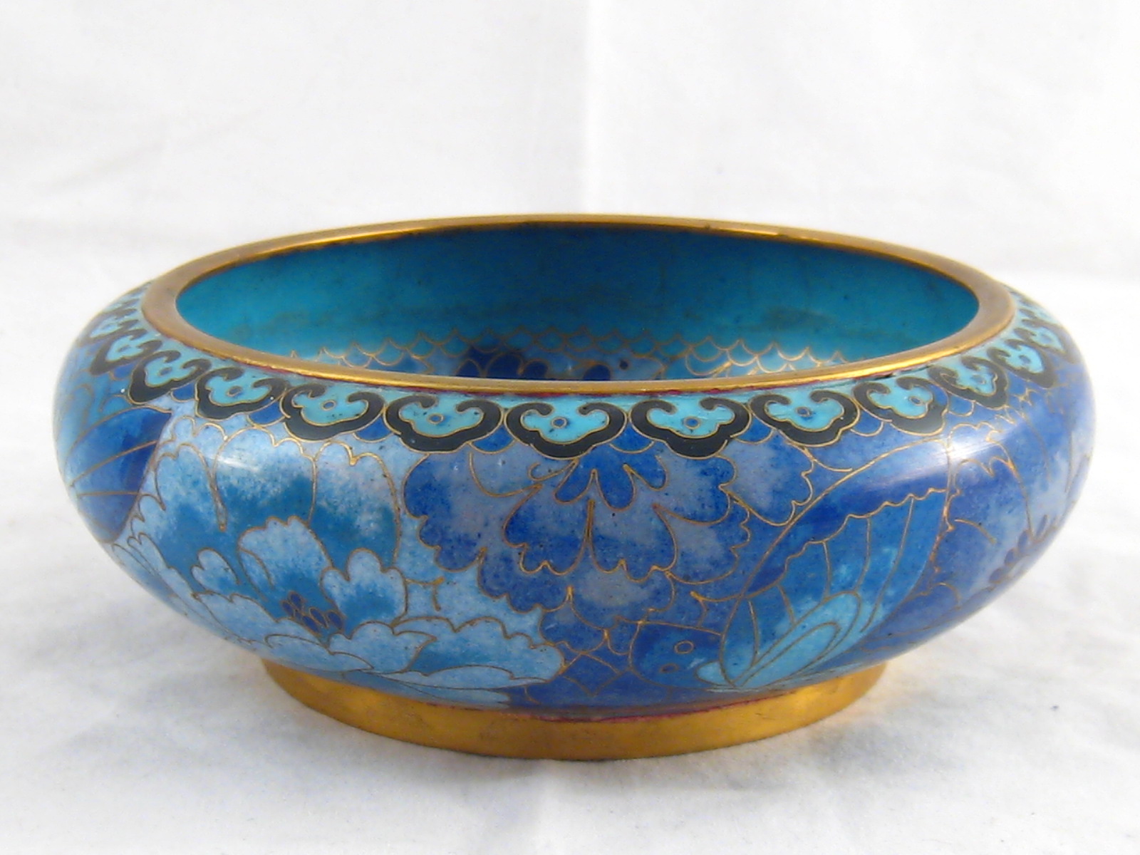 A brass bowl cloisonne enamelled with butterflies and flowers in shades of blue. 15cm. diameter.