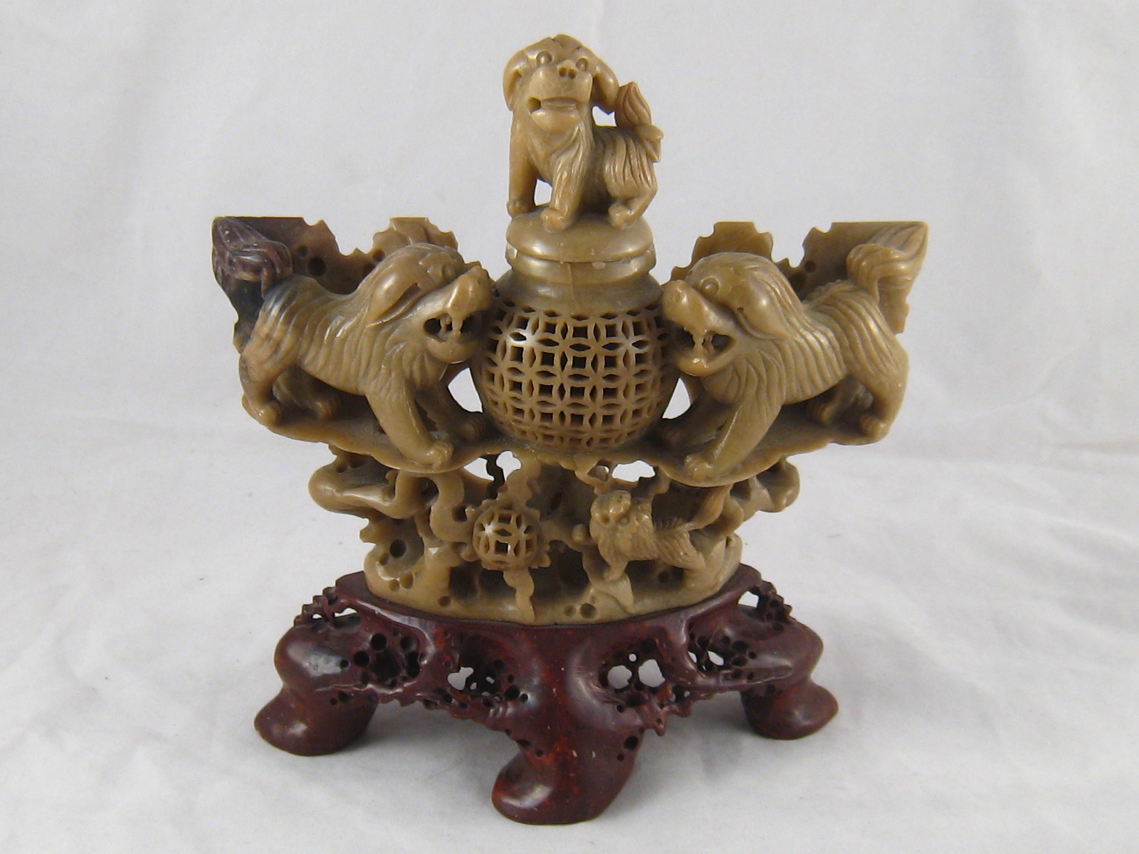 A Chinese hardstone carving with temple lions guarding a censer pot with lion finial cover. Ht.