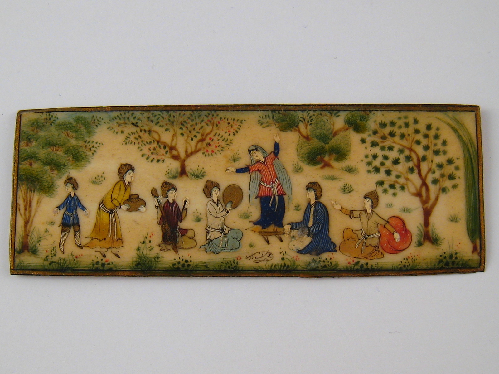 A Persian ivory panel of a group of musicians and a dancer girl. 10.5x4cm.