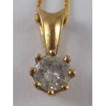 A yellow metal (tests 9 carat gold) diamond solitaire pendant and chain,