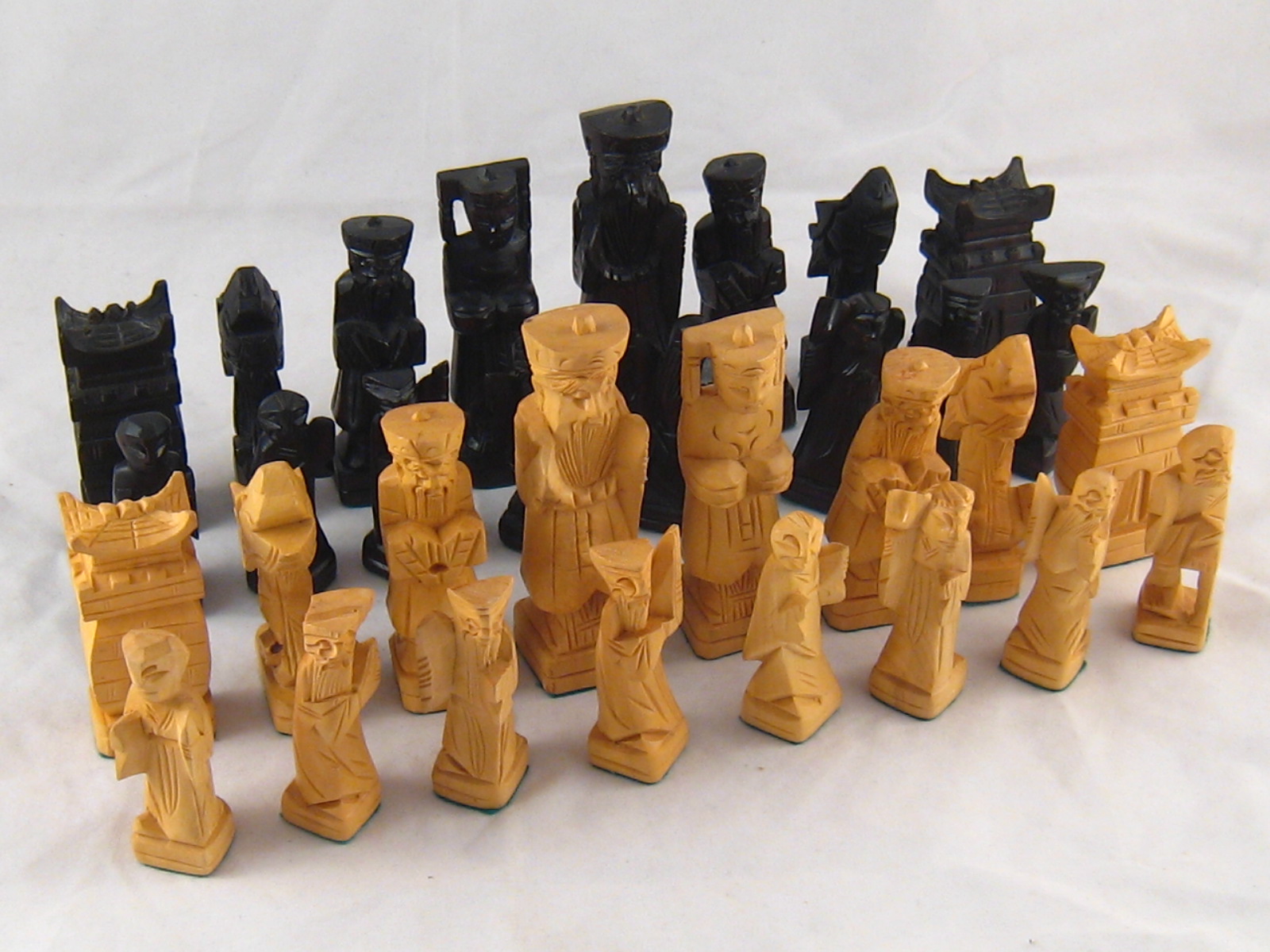 A carved Chinese wooden chess set. Ht. queen. 10cm.