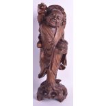 A LATE 19TH CENTURY CHINESE CARVED HARDWOOD FIGURE OF A BUDDHIST modelled holding a basket in one
