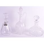 AN EDWARDIAN CUT GLASS DECANTER AND STOPPER together with two other decanters & stoppers. Largest