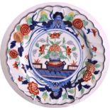 AN 18TH CENTURY CHELSEA DERBY SCALLOPED PLATE painted in the Chinese style with an urn of flowers.