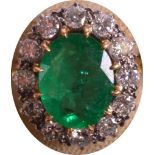 A GOOD 18CT YELLOW GOLD LADIES EMERALD RING encased within twelve brilliant cut diamonds.