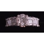 A LADIES 18K WHITE GOLD DIAMOND RING with central stone flanked by six baguette cut diamonds. 4.