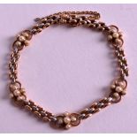AN EDWARDIAN LADIES 9CT ROSE GOLD AND SILVER BRACELET with floral seed pearl surround. 12.5grams.