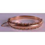 A 9CT YELLOW GOLD BANGLE with filigree type border. 10.7 grams. 2.25ins wide.