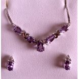 AN ART DECO DESIGN 9CT WHITE GOLD NECKLACE AND EARRING SET formed with amethyst and diamonds.