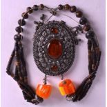 AN EARLY 20TH CENTURY TIBETAN WHITE METAL AND AMBER NECKLACE with wooden bead fittings. Pendant 4.