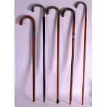 A GROUP OF FIVE VICTORIAN AND LATER SILVER TOPPED WALKING CANES of various forms. (5)