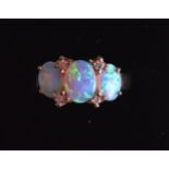 A LOVELY LADIES 9CT YELLOW GOLD THREE STONE DIAMOND AND OPAL ETERNITY RING. 4.2grams.