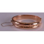 AN EDWARDIAN 9CT YELLOW GOLD BANGLE with floral decoration. Birmingham 1919. 13.6 grams. 2.5ins