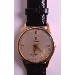 A 1950S GENTLEMANS 9CT YELLOW GOLD OMEGA WRISTWATCH with brown leather strap and gold cased dial.