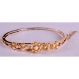 A VICTORIAN 15CT YELLOW GOLD BANGLE with pretty floral design, set with seed pearls. 9 grams. 2.