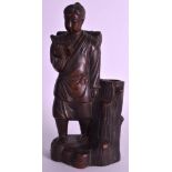 A LATE 19TH CENTURY JAPANESE MEIJI PERIOD POTTERY FIGURE OF A MALE modelled holding an open book.